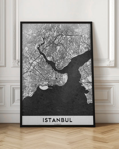 A modern black and white framed poster of a city map of Istanbul. The land is depicted in white with intricate black lines representing streets, while the bodies of water like the Bosphorus are shown in solid textured black. A white banner at the bottom displays the word 'ISTANBUL' in a bold, black, sans-serif font. Artwork