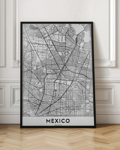 A modern, minimalist black and white art print of a street map of Mexico City, enclosed in a simple black frame. The intricate road network is depicted with black lines on a textured white background. The word 'MEXICO' is printed in bold, black capital letters at the bottom. Print