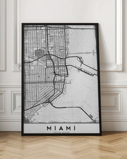 A minimalist black and white street map of Miami, Florida, with a distressed, textured background. The map is framed in black with the word 'MIAMI' printed in bold capital letters at the bottom. Artwork