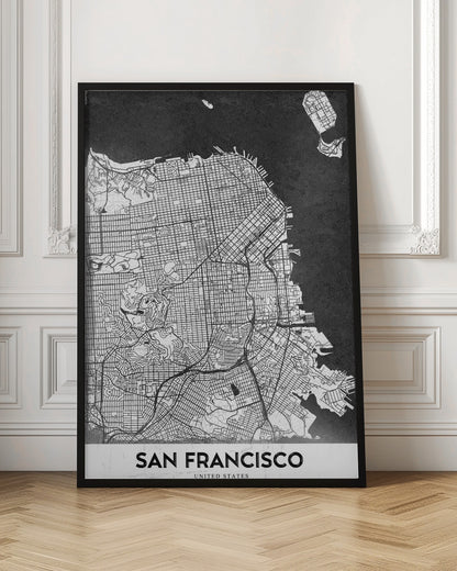 A minimalist black and white art print of a San Francisco city map. The street grid and landmass are depicted in white with fine black lines, set against a solid black background representing the water. A black frame surrounds the map, and a white banner at the bottom displays the text 'SAN FRANCISCO' in a bold, black font. Wall Art