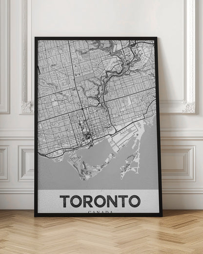 A modern, black and white poster featuring a stylized street map of Toronto, Canada. The map is in a black frame, and the word 'TORONTO' is written in bold, black, distressed letters at the bottom. Print