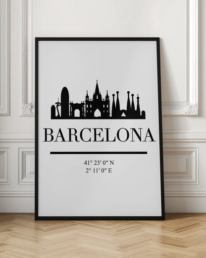 A minimalist black and white poster of Barcelona, Spain. It features a black silhouette of the city's skyline, including the Sagrada Familia, above the word 'BARCELONA' in a large serif font. Below the city name are its geographical coordinates, all set against a clean white background and framed in black. Print