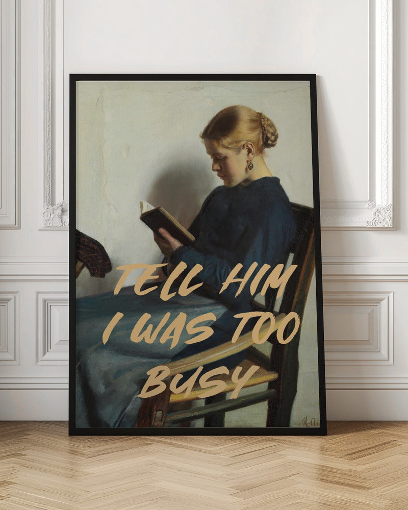 A classical painting of a woman in a blue dress sitting in a wooden chair, engrossed in reading a book. Overlaid in a modern, tan-colored brush script font is the phrase 'TELL HIM I WAS TOO BUSY'. Wall Art