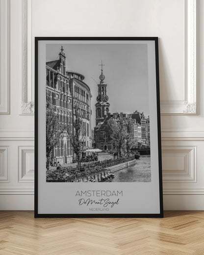 A black and white travel poster of Amsterdam, Netherlands. The photo shows the Munttoren clock tower and traditional Dutch buildings along the Singel canal. A floating barge filled with bicycles is in the foreground. The poster has a white border with the text 'AMSTERDAM', 'De Munt, Singel', and 'NEDERLAND' at the bottom. Artwork