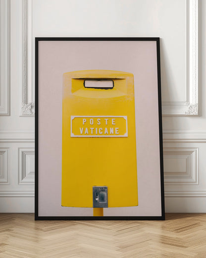 A close-up, front-view photograph of a vibrant yellow Vatican City mailbox against a plain beige wall, enclosed in a thin black frame. The words 'POSTE VATICANE' are printed in white on the front. Artwork
