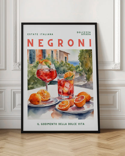 A vintage-style poster for a Negroni cocktail with the words 'Estate Italiana' and 'Negroni' at the top. The poster features a watercolor illustration of two glasses of Negroni on a white table with fresh oranges, set against a sunny Italian coastal backdrop with a villa and the sea. At the bottom, it reads 'Il Godimento Della Dolce Vita'. Artwork