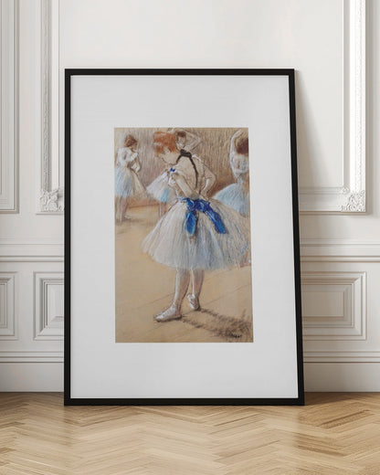 A framed print of an impressionist pastel drawing by Edgar Degas. It shows a ballerina in a white and light blue tutu with a prominent royal blue sash. She is viewed from the side as she adjusts her costume, with other dancers blurred in the background of a dance studio. Poster