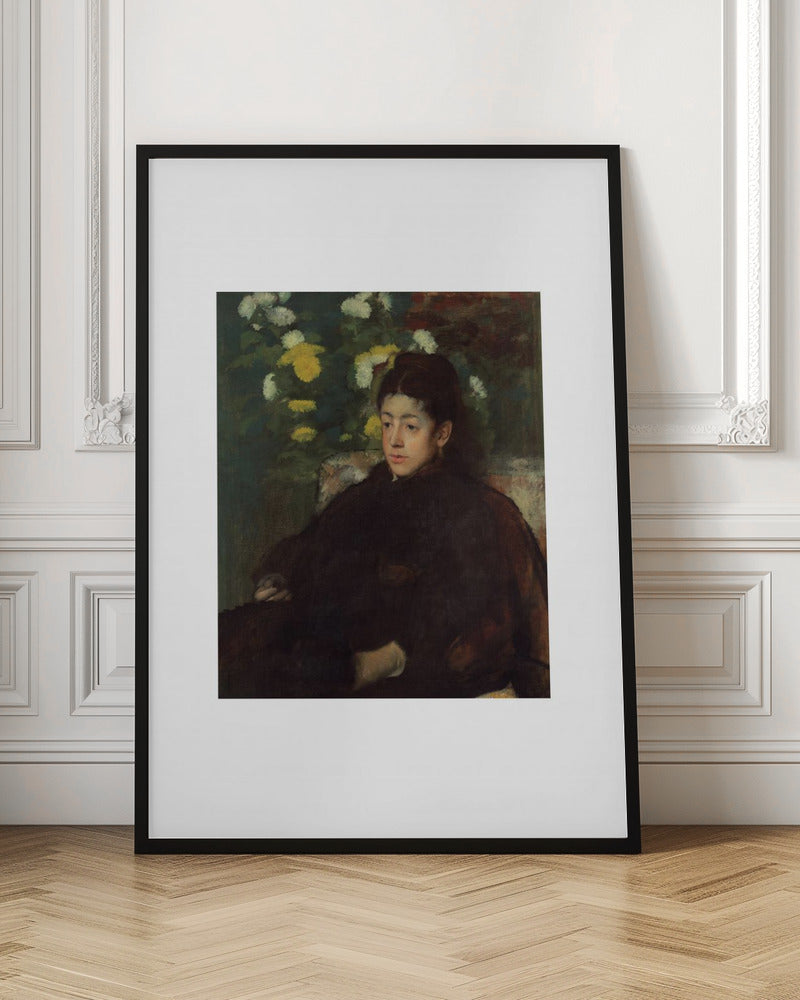 A framed impressionist portrait painting by Edgar Degas of a young woman with dark hair pulled back, wearing a voluminous dark dress. She sits in a chair with a pensive look, set against a background of yellow and white chrysanthemums and dark green foliage. Decor