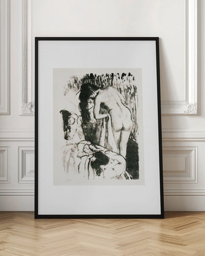 A framed black and white lithograph by Edgar Degas of a nude woman with long dark hair, viewed from the back as she leans over. The artwork has a sketchy, impressionistic style, capturing an intimate moment. Wall Art