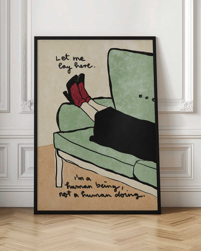 An illustration of a person's lower legs and feet propped up on a sage green armchair. The person wears red patterned socks and black high heels. Handwritten text above the feet reads, 'Let me lay here.' and text at the bottom reads, 'I'm a human being, not a human doing.' The background is a neutral beige, and the artwork has a simple, hand-drawn style with black outlines. Decor