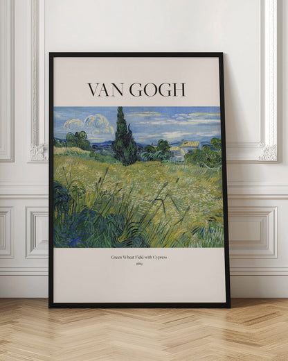 A framed art print of Vincent van Gogh's painting 'Green Wheat Field with Cypress' from 1889. The impressionist painting features a vibrant green and yellow field, a prominent dark cypress tree, and a blue sky with white clouds. The poster has a cream border with 'VAN GOGH' printed at the top and the title and year at the bottom. Poster