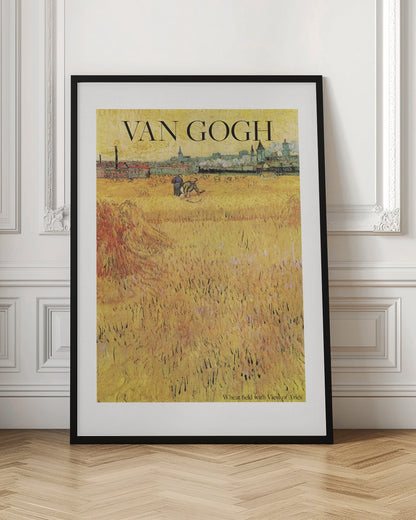 A framed poster of Vincent van Gogh's painting 'Wheat Field with View of Arles'. The impressionist artwork features a vast, textured golden wheat field with harvesters, and the city of Arles in the background. The title 'VAN GOGH' is printed prominently at the top. Decor