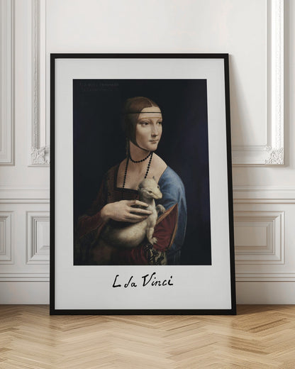 A framed art print of Leonardo da Vinci's painting, 'Lady with an Ermine'. The Renaissance portrait shows a woman holding a white ermine. The print has a white border with 'L da Vinci' signed at the bottom, mimicking a polaroid. Artwork