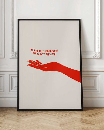 A minimalist poster with a cream background in a black frame. It features a stylized red illustration of an outstretched hand, palm up. Above the hand, red text in a casual font reads 'DU KAN INTE MISSLYCKAS OM DU INTE FÖRSÖKER,' which is Swedish for 'You can't fail if you don't try.' Poster