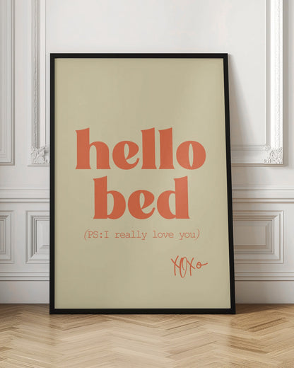 A framed art print with a cream-colored background. The words 'hello bed' are printed in a large, bold, orange serif font. Below this, in a smaller orange font, it reads '(PS: I really love you)'. In the bottom right corner, 'XOXO' is written in an orange script font. Decor