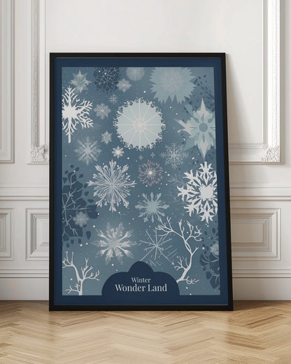 A vertical art print with a winter theme, featuring a variety of white and light blue snowflakes of different sizes and intricate designs scattered across a dusty blue background. At the bottom, silhouettes of bare white tree branches are visible, and a dark blue cloud-like shape holds the text 'Winter Wonder Land' in a white font. The artwork is framed in black. Artwork