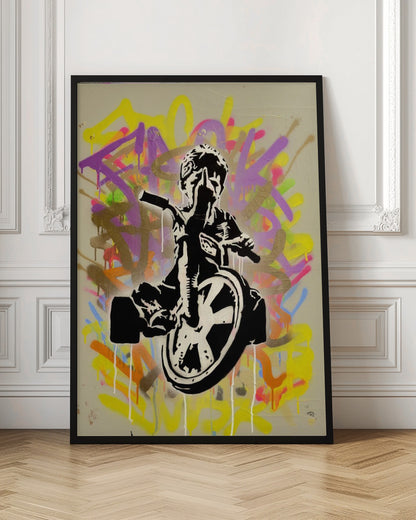A framed street art piece featuring a black and white stencil of a rebellious child on a tricycle giving the middle finger, set against a vibrant, multi-colored graffiti background with paint drips. Artwork