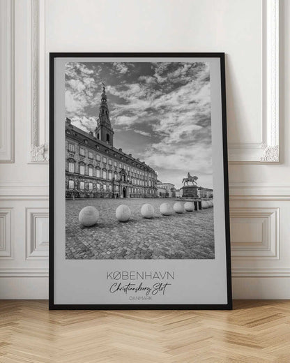 A black and white travel poster of Christiansborg Palace in Copenhagen, Denmark. The image shows the grand building and its tower against a dramatic cloudy sky, with a cobblestone square, stone bollards, and an equestrian statue in the foreground. Text at the bottom identifies the location. Decor