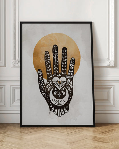 A black-and-white illustration of a hand decorated with intricate folk art symbols, including an eye within a heart on the palm, a crescent moon, and floral motifs on the fingers. A large, textured golden circle, like a sun or moon, serves as the background, set against a light gray, watercolor-style canvas. Decor