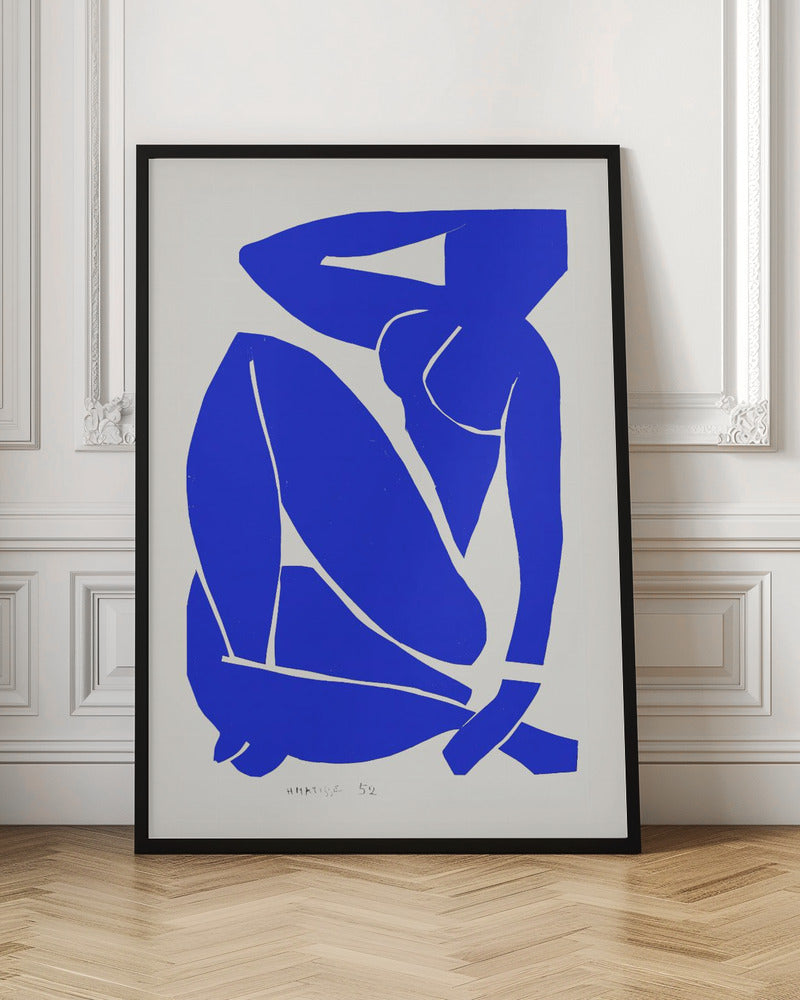 A framed print of Henri Matisse's 'Blue Nude II', featuring a bold, royal blue paper cutout of a seated female nude against an off-white background. The figure is stylized and abstract, with limbs folded and one arm behind her head. Print