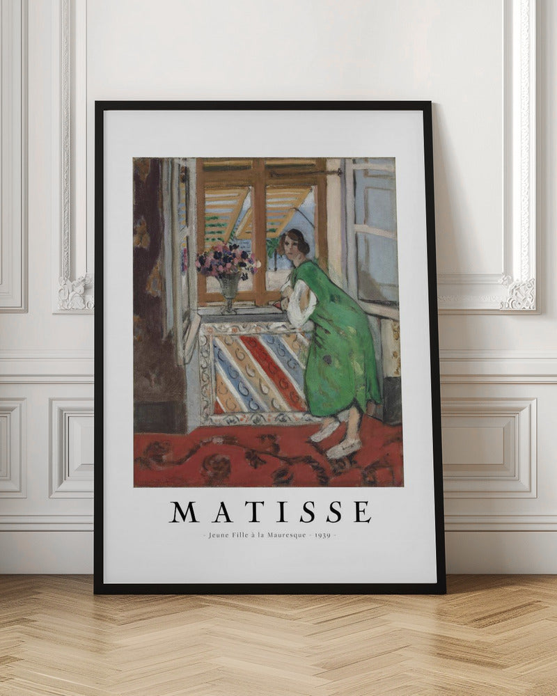 A framed art print of Henri Matisse's painting 'Jeune Fille à la Mauresque - 1939'. The painting shows a woman in a vibrant green dress standing in a room and looking out of an open window with shutters. A red patterned rug covers the floor, and a vase of flowers sits on the windowsill. Poster