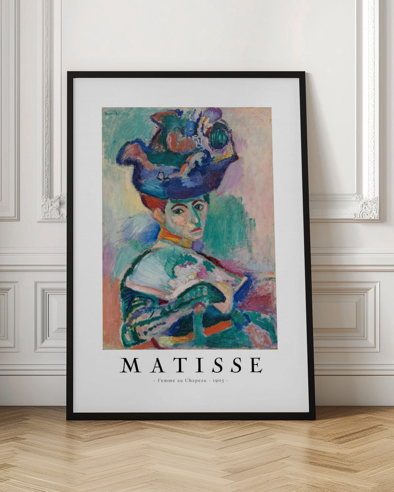 A framed art print of Henri Matisse's famous 1905 Fauvist painting, 'Femme au Chapeau' (Woman with a Hat). The portrait features a woman with an extravagantly decorated, colorful hat, painted with bold, non-naturalistic colors and expressive brushstrokes. Print