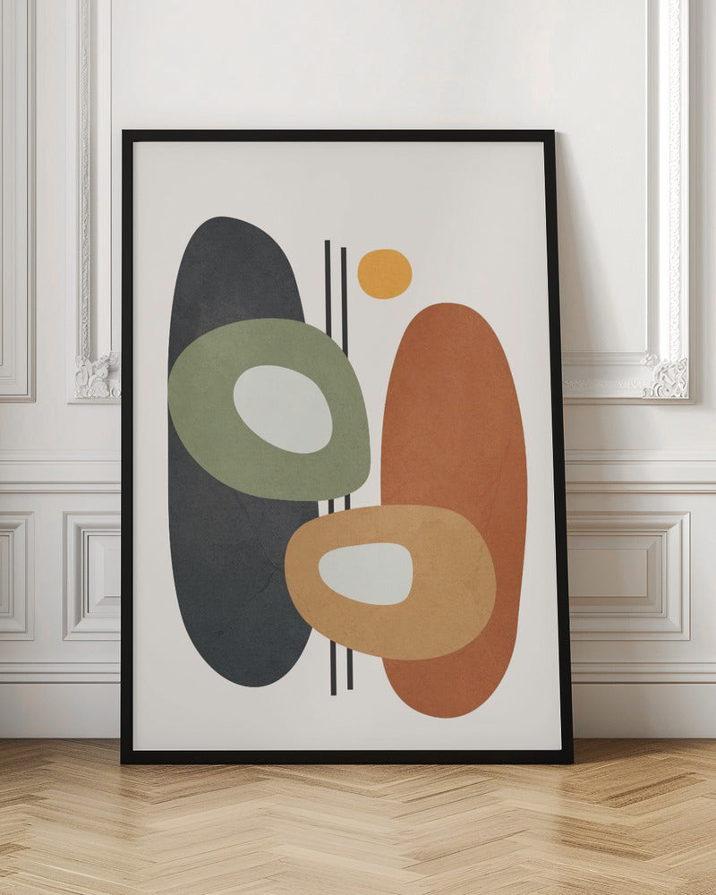 An abstract art print in a black frame, featuring a collection of overlapping organic shapes in muted earth tones. A large dark gray oval is on the left, next to a burnt orange oval on the right. In front of them are two ring-like shapes, one olive green and one light orange, both with off-white centers. A small yellow circle is near the top, and thin vertical black lines cut through the composition. The background is a soft off-white. Print