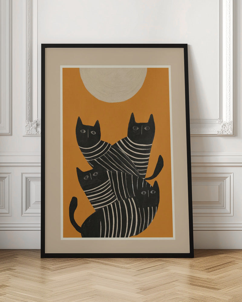 A framed art print of a stylized illustration featuring four black cats with white striped bodies stacked together. They are set against a solid orange background with a large, textured, cream-colored moon or sun at the top. Artwork