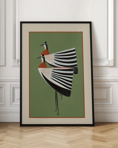 A framed art print featuring two highly stylized birds standing against a solid sage green background. The birds have boat-shaped bodies with bold black and white stripes, orange chests, and long thin black legs and beaks. Wall Art