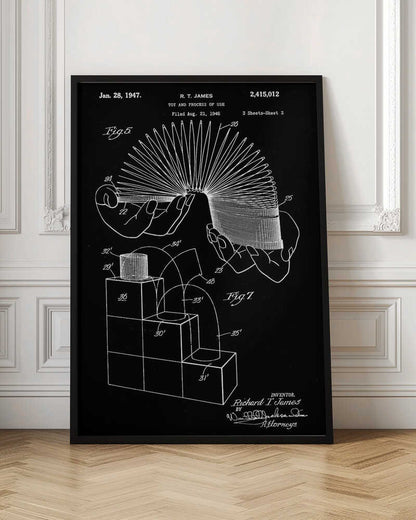 A framed black and white patent illustration for the Slinky toy, invented by R. T. James, dated January 28, 1947. The technical drawing shows hands holding the stretched coil and a diagram of the toy walking down stairs. Decor