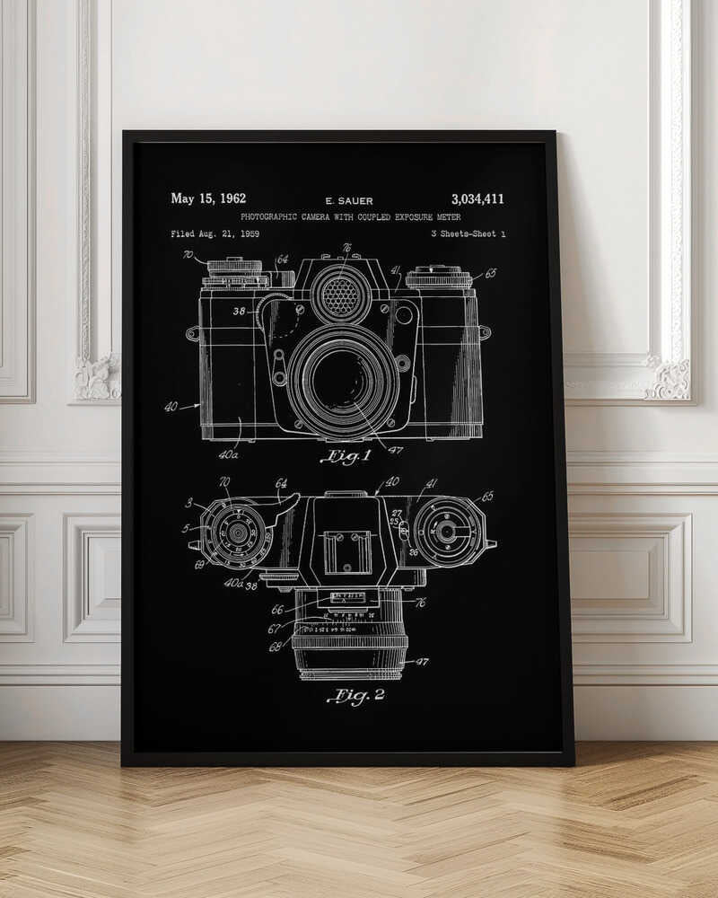 A framed patent illustration of a photographic camera from 1962, presented as a white line drawing on a black background. The poster shows two figures: Fig. 1 is a front view of the camera, and Fig. 2 is a top-down view. Both diagrams are detailed with numbers and lines pointing to various components. The top of the poster includes text with the patent date, inventor's name (E. Sauer), and patent number. Poster