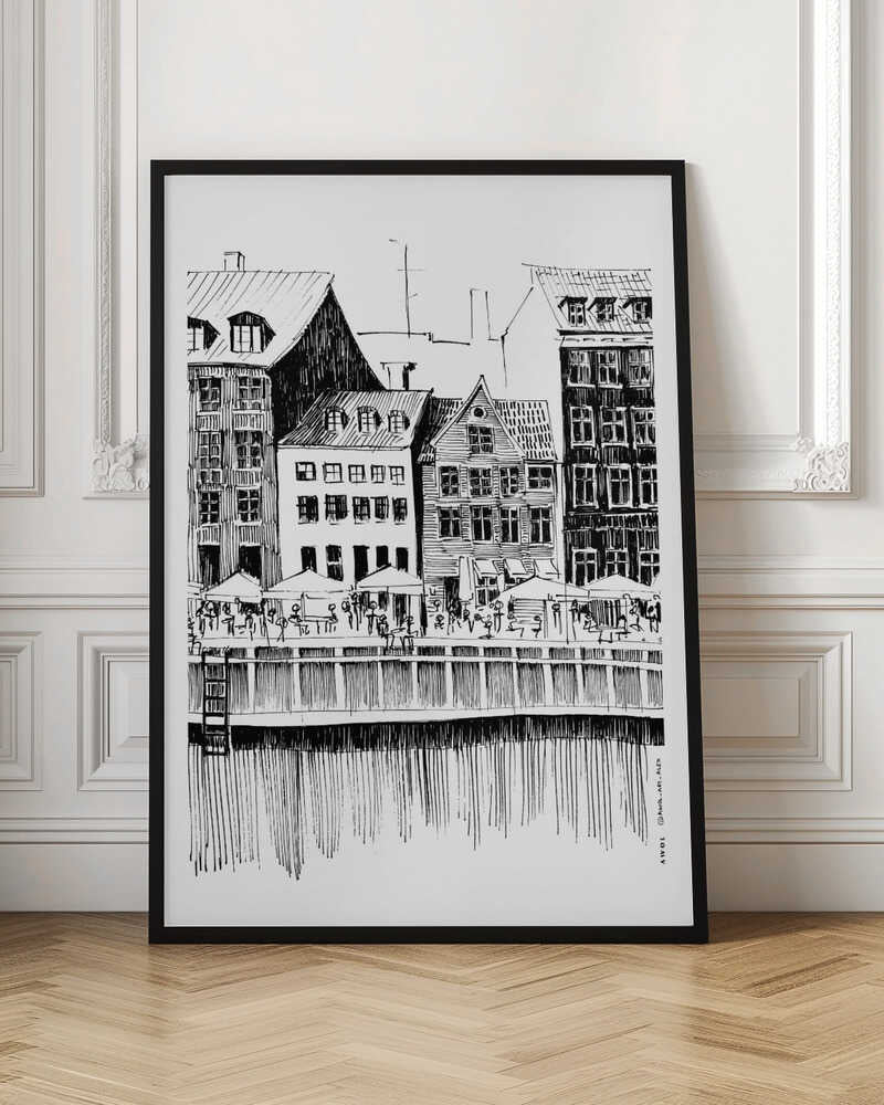 A black and white ink line drawing of a charming European city scene along a canal. Tall, narrow buildings with gabled roofs line the waterfront, in front of which is a bustling pier with outdoor cafes filled with people under umbrellas. The water's reflection is illustrated with simple vertical lines. The artwork is framed in black. Wall Art