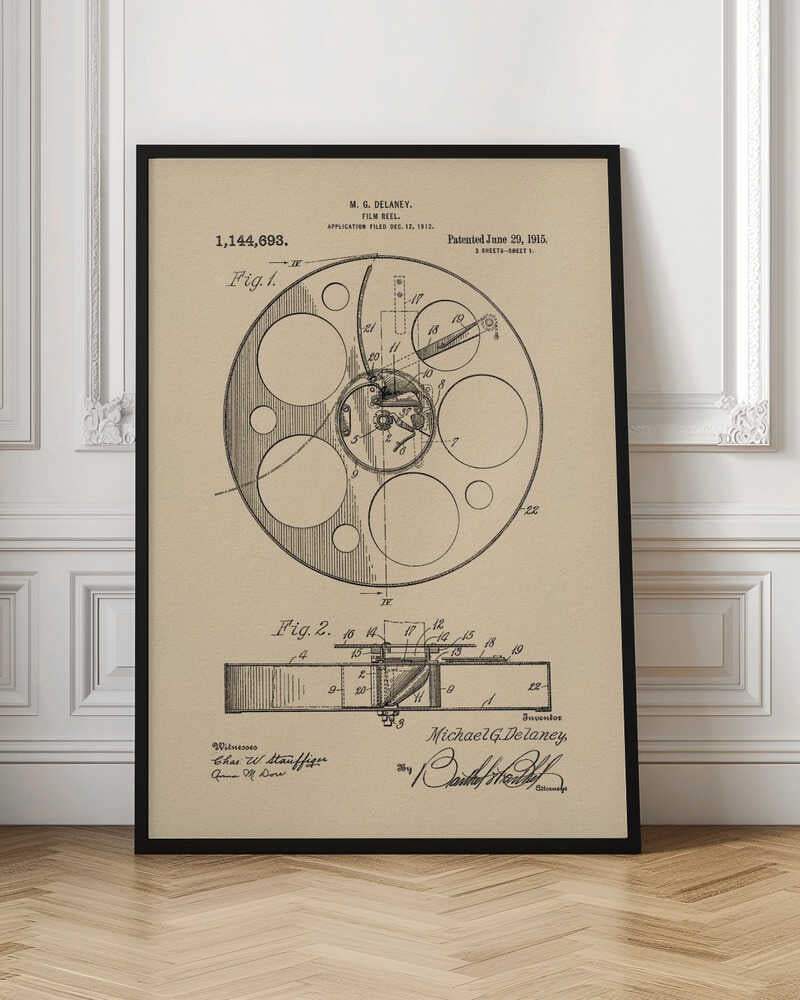 A framed vintage patent illustration of a film reel from 1915 by M.G. Delaney. The drawing is in black ink on a beige background, showing detailed schematics of the reel's mechanics from two different angles, complete with numbered parts, signatures, and patent information. Wall Art