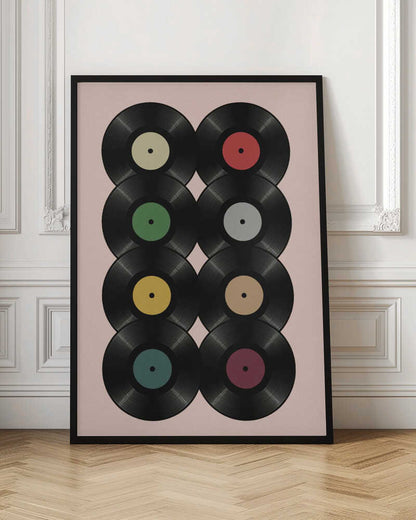 A graphic art print featuring eight black vinyl records arranged in two columns of four against a pale pink background. Each record has a different solid-colored label, creating a colorful and retro pattern. The artwork is enclosed in a simple black frame. Artwork