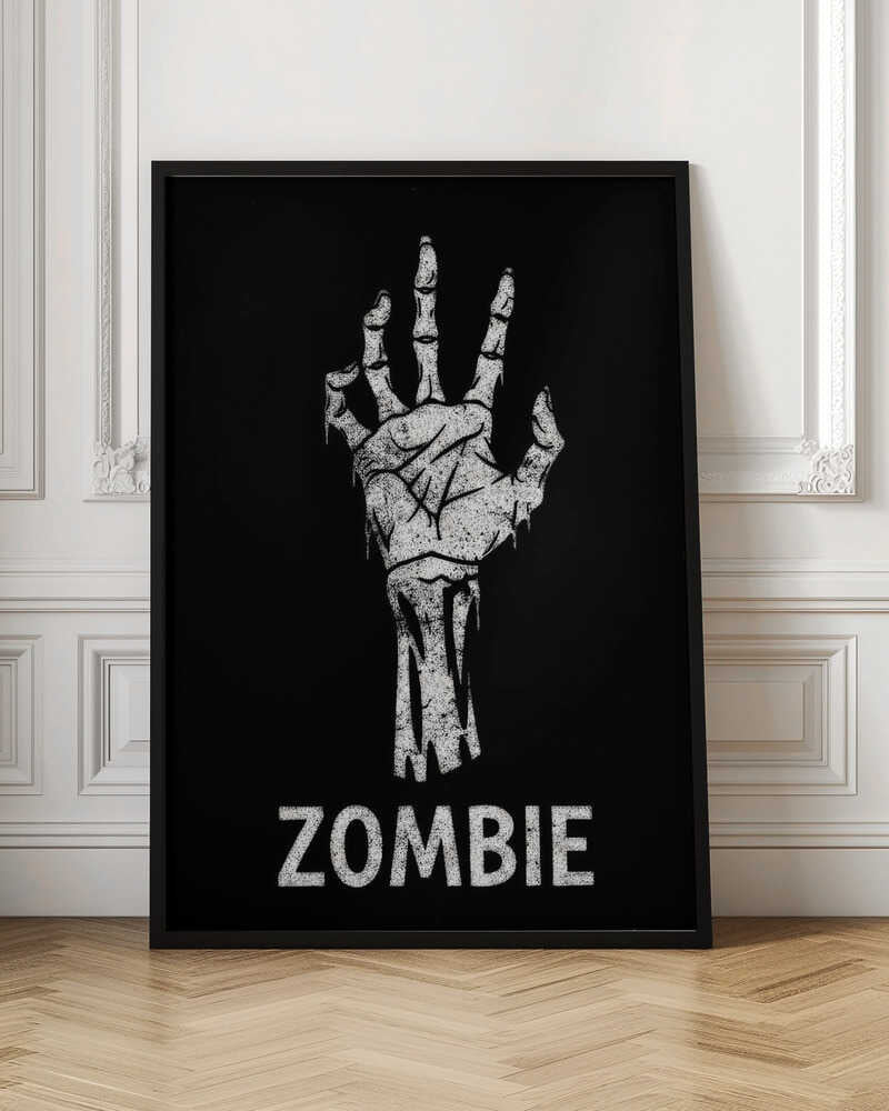A black and white graphic of a distressed, skeletal zombie hand reaching up against a solid black background. Below the hand, the word 'ZOMBIE' is written in a bold, distressed font. The entire image is bordered by a thin black frame. Decor