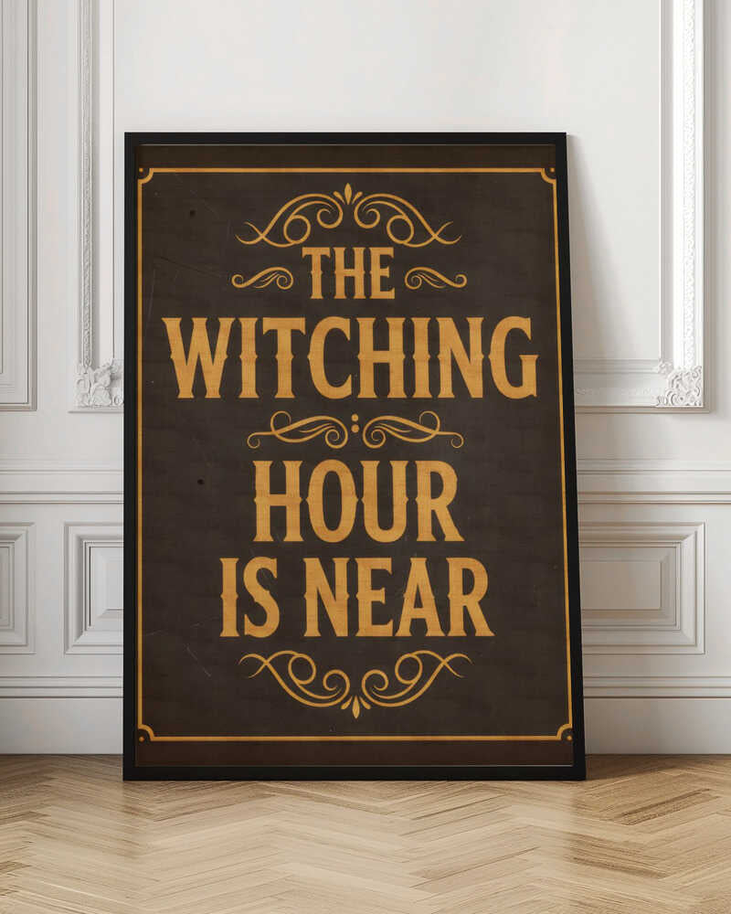 A framed vintage-style sign with a dark brown, distressed background. In a bold, golden-yellow serif font, the text reads 'THE WITCHING HOUR IS NEAR'. The text is adorned with ornate, swirling flourishes above, between, and below the lines. A thin golden-yellow border frames the entire design. Poster