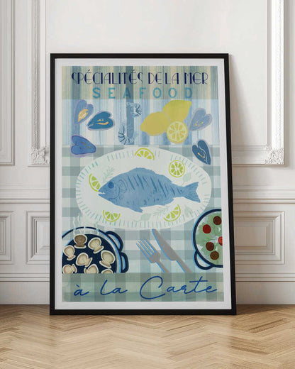 A vintage-style illustrated poster advertising seafood with French text. It features a platter with a whole blue fish and lemon slices on a blue and white checkered tablecloth, surrounded by mussels, shrimp, lemons, a pan of scallops, and a salad. Artwork