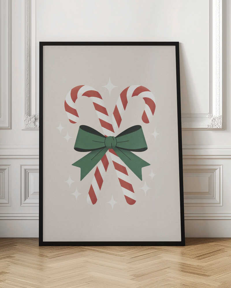 An illustration of two red-and-white striped candy canes crossed and tied together with a large green bow. The background is a soft beige color with small, white, four-pointed star sparkles. The artwork is shown in a black frame. Decor