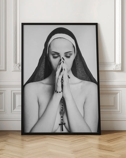 A black and white portrait of a woman with dramatic eye makeup wearing a nun's habit. Her eyes are closed and her hands are clasped in front of her face in prayer, holding a black rosary. Her shoulders are bare, creating a stark contrast. Artwork