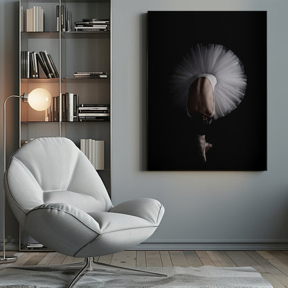 A dramatic photograph of a ballerina against a solid black background. She is bent completely forward, showing her arched back to the camera. Her white tutu fans out in a wide circle around her, and one foot in a pointe shoe is visible beneath her, balanced on its tip. Print