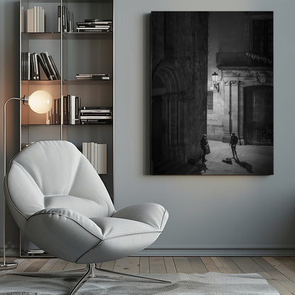 A high-angle, black and white photograph of a street musician playing a saxophone for a lone listener in a narrow stone alley at night. The scene is illuminated by an ornate streetlamp, casting long shadows on the cobblestone ground. Wall Art