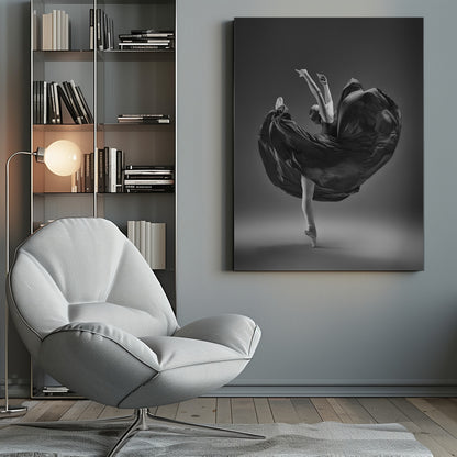 A dramatic black and white photograph of a ballerina captured mid-twirl. She is perfectly balanced on the tip of one pointe shoe, with her other leg kicked high. Her arms are raised elegantly above her head, and her long, dark dress billows out around her in a magnificent, fluid circle against a solid gray background. Wall Art