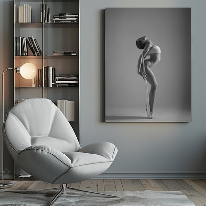 A framed black and white photograph of a graceful female dancer arching her back dramatically. She holds a long white elastic band that stretches down her body to her foot, emphasizing her athletic form and flexibility against a plain studio background. Print