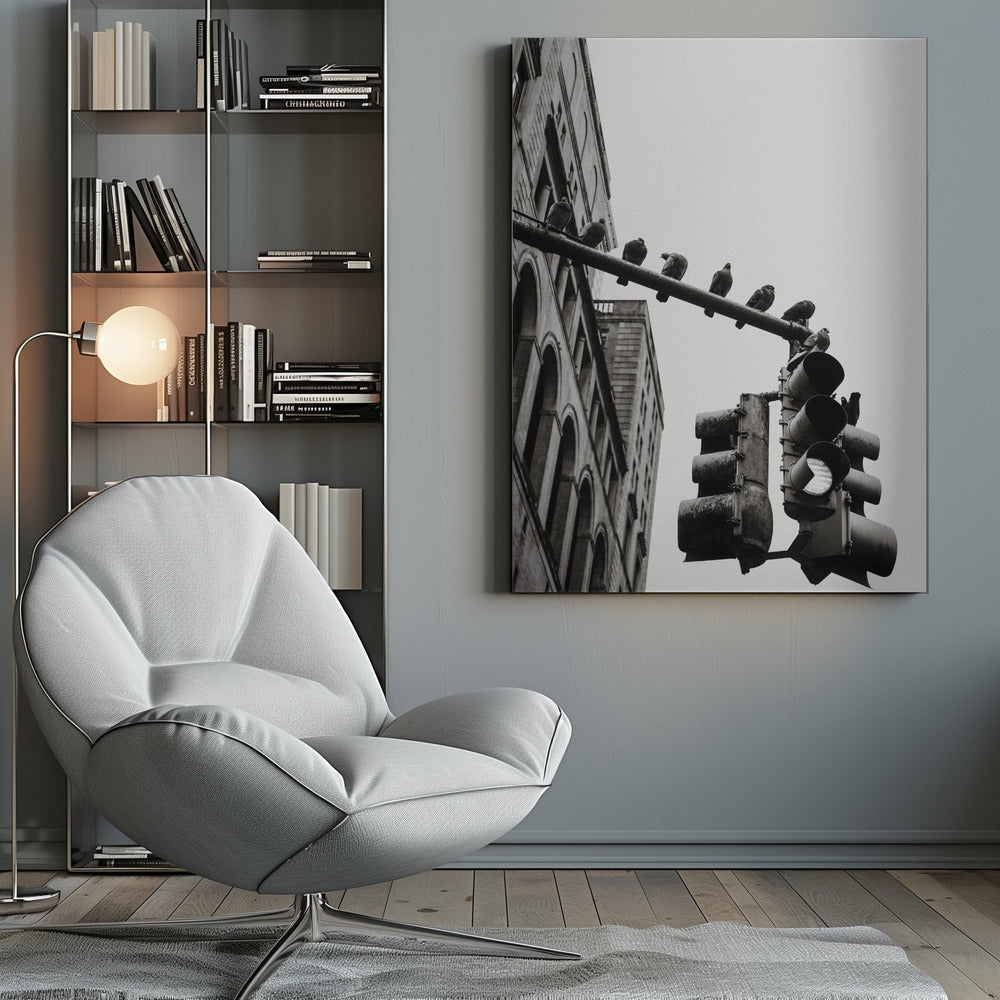 A low-angle, black and white photograph of pigeons perched along a traffic light arm, with a large city building in the background against a gray sky. Wall Art