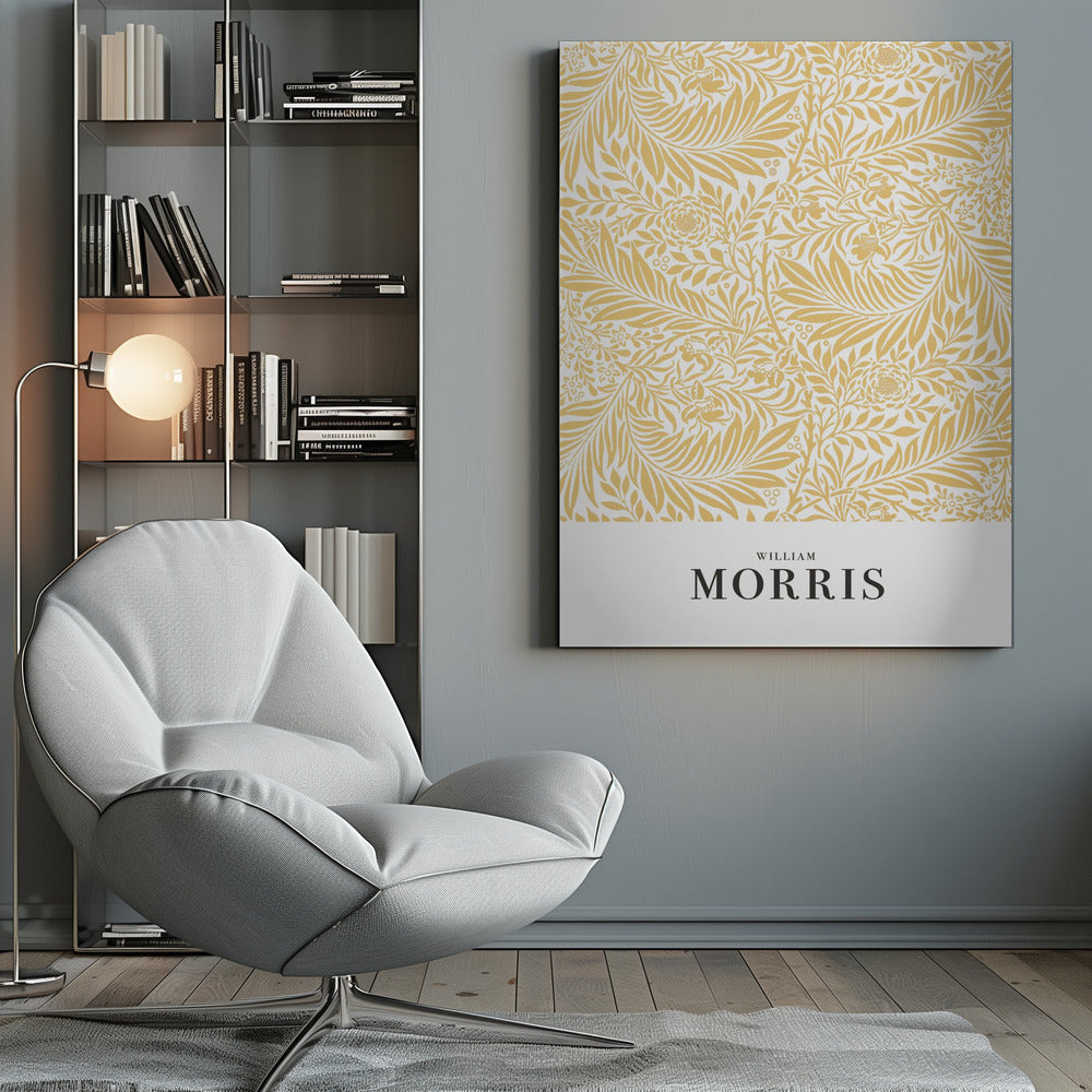 A framed exhibition-style poster of a William Morris design. The poster features an intricate, golden-yellow floral and leaf pattern on a white background. Below the pattern, the name 'WILLIAM MORRIS' is printed in black text. The entire artwork is presented in a simple black frame. Wall Art