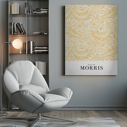 A framed exhibition-style poster of a William Morris design. The poster features an intricate, golden-yellow floral and leaf pattern on a white background. Below the pattern, the name 'WILLIAM MORRIS' is printed in black text. The entire artwork is presented in a simple black frame. Wall Art