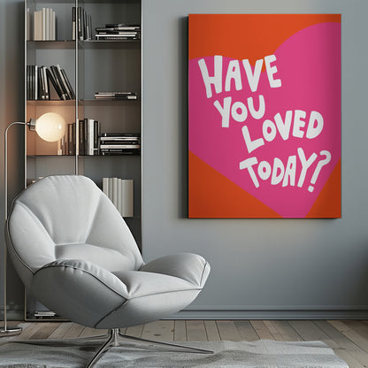 A framed art print with the text 'Have you loved today?' in a playful white font. The text is centered on a large pink heart which is set against a vibrant orange background. Artwork