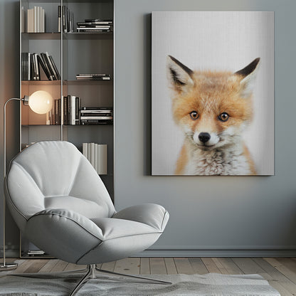 A close-up portrait of a young fox cub looking directly into the camera. The cub has vibrant orange and white fur, large brown eyes, and is set against a simple white textured background, all within a thin black frame. Print