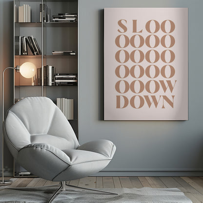 A minimalist art print with the phrase 'Slow Down' in a brown serif font against a pale pink background. The word is styled vertically, with 'SLOO' on the top line, followed by multiple lines of 'OOOO', and ending with 'OOW' and 'DOWN', visually stretching the word to emphasize the message. Artwork