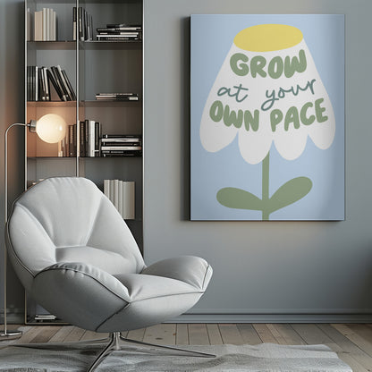 A motivational art print featuring a stylized white flower with a yellow center and green stem against a light blue background. The phrase 'GROW at your OWN PACE' is written in green, hand-drawn lettering across the flower's petals. Artwork